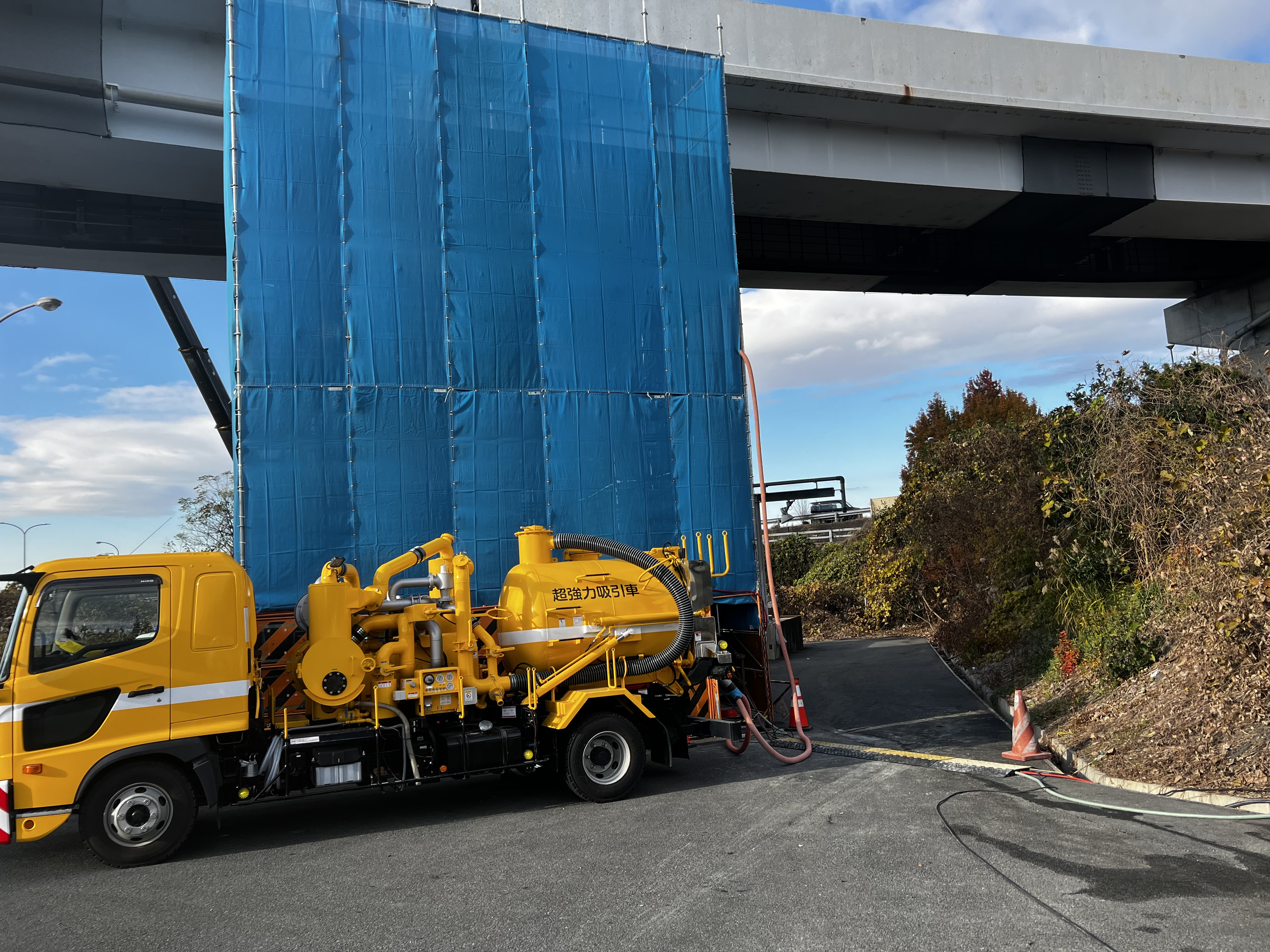 高架下で作業する株式会社秀栄の超強力吸引車